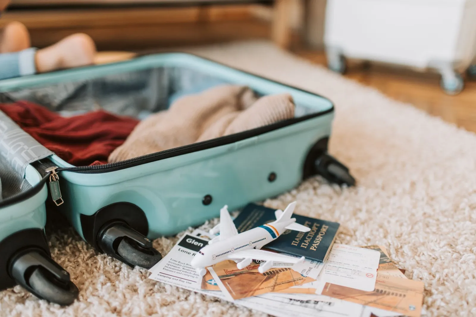 Close-up of an open suitcase with travel essentials like passport and tickets, ready for a journey.