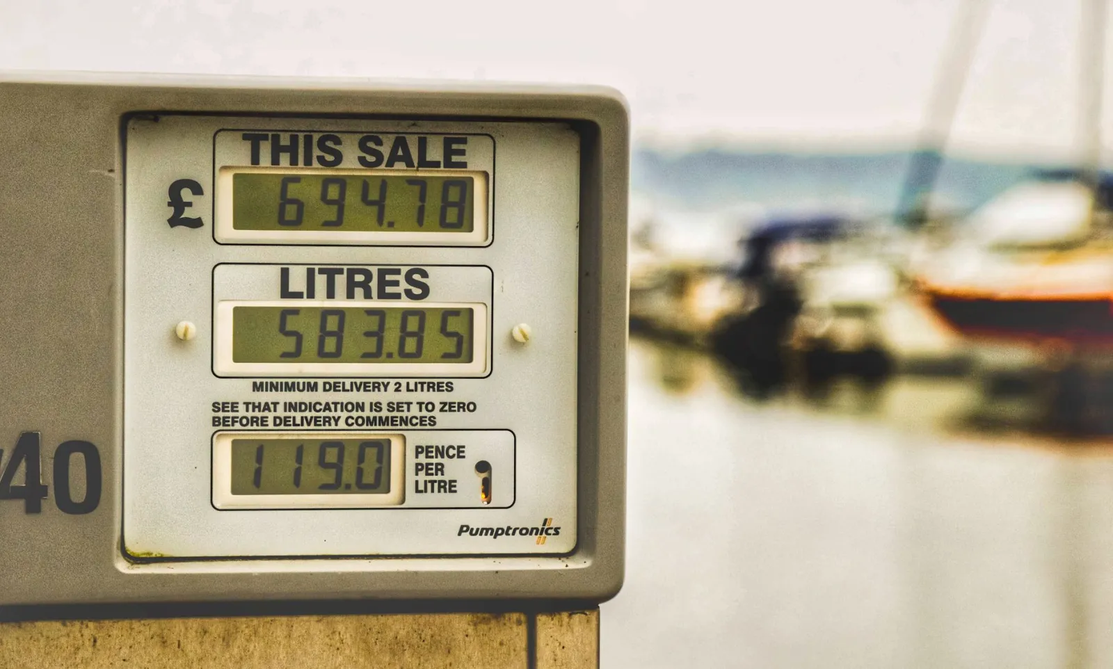 Blurred background view with focus on fuel pump display showing price and liters.